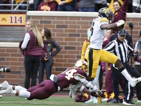 Iowa wide receiver Ihmir Smith-Marsette runs the ball into the end zone through the arms of Minnesota's defensive back Antonio Shenault during an NCAA college football game Saturday, Oct. 6, 2018, in Minneapolis.