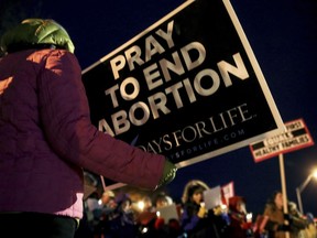 FILE - In this Dec. 12, 2016, file photo, protesters hold anti-abortion signs outside the Planned Parenthood Columbia Health Center on in Columbia, Mo. Planned Parenthood Great Plains spokeswoman Emily Miller says abortions scheduled for Wednesday, Oct. 3, 2018, at the Columbia clinic are canceled. Federal appeals judges ruled last month that Missouri can enforce a requirement that doctors performing abortions must have admitting privileges at hospitals. The Columbia clinic hasn't met that requirement.