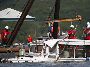 FILE - In this July 23, 2018, file photo, a duck boat that sank during a thunderstorm on July 19, killing 17 people on Table Rock Lake in Branson, Mo., is raised from the bottom of the lake. A company facing multiple lawsuits over the summer tourist boat accident in Missouri has invoked an 1851 law that allows vessel owners to try to limit their legal damages as it also seeks settlement negotiations with victims' family members. Attorneys for Ripley Entertainment Inc., based in Orlando, Fla., cited an old federal law in a filing Monday, Oct. 15, 2018, in federal court in western Missouri.