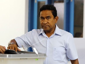 FILE - In this Sunday, Sept. 23, 2018, file photo. Maldivian President Yameen Abdul Gayoom, right, casts his vote at a polling station during presidential election day in Male, Maldives. Yameen, the outgoing president of the Maldives has filed a complaint with police challenging the results of last month's presidential election, which he lost to the opposition candidate.