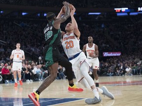 New York Knicks forward Kevin Knox (20) lands on his ankle as he drives to the basket against Boston Celtics guard Terry Rozier (12) during the first half of an NBA basketball game, Saturday, Oct. 20, 2018, at Madison Square Garden in New York.
