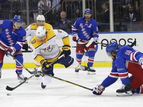 Nashville Predators' Craig Smith (15) fights for control of the puck with New York Rangers' Marc Staal (18) during the first period of an NHL hockey game Thursday, Oct. 4, 2018, in New York.