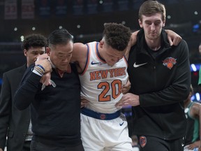 New York Knicks forward Kevin Knox (20) is helped off the court after injuring himself during the first half of an NBA basketball game against the Boston Celtics, Saturday, Oct. 20, 2018, at Madison Square Garden in New York.
