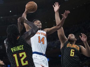 New York Knicks guard Allonzo Trier (14) goes to the basket against Atlanta Hawks forward Taurean Prince (12) and forward Omari Spellman (6) during the second half of an NBA basketball game, Wednesday, Oct. 17, 2018, at Madison Square Garden in New York. The Knicks won 126- 107.