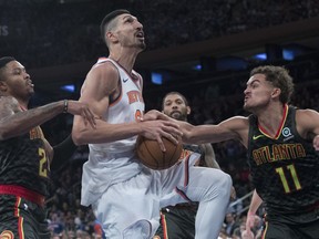 Atlanta Hawks guard Trae Young (11) fouls New York Knicks center Enes Kanter, center, during the second half of an NBA basketball game, Wednesday, Oct. 17, 2018, at Madison Square Garden in New York. The Knicks won 126- 107.