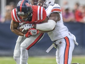 Mississippi wide receiver DaMarkus Lodge (5) is tackled by Auburn defensive back Daniel Thomas (24) during an NCAA college football game at Vaught-Hemingway Stadium in Oxford, Miss., Saturday, Oct. 20, 2018.