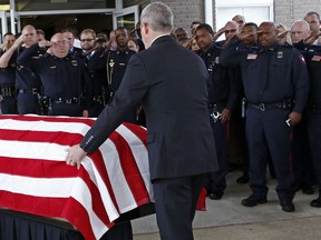 Brookhaven police officers salute as the flag draped coffin of Brookhaven, Miss., police officer James White, rolled towards the waiting hearse following his funeral service, Wednesday, Oct. 3, 2018, at Easthaven Baptist Church in Brookhaven. White and Corporal Zach Moak were killed early Saturday, Sept. 30, responding to a call.