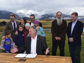 U.S. Interior Secretary Ryan Zinke, center, is surrounded by residents, business people and family members as he signs a 20-year mining moratorium on lands in Paradise Valley, Mont. on Monday, Oct. 8, 2018 at Sage Resort in Pray, Mont.  Zinke approved a 20-year ban on new mining claims in the mountains north of Yellowstone National Park after two proposed gold mines raised concerns the area could be spoiled.