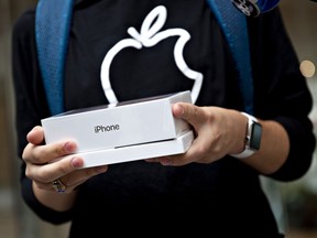 A customer holds an Apple iPhone XS Max box at a store in Chicago in 2018.