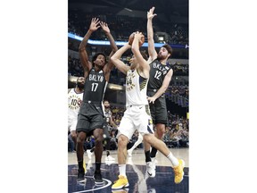 Indiana Pacers forward Bojan Bogdanovic (44) gets to the basket defended by Brooklyn Nets center Ed Davis (17) and Brooklyn guard Joe Harris in the first half of an NBA basketball game, Saturday, Oct. 20, 2018, in Indianapolis.