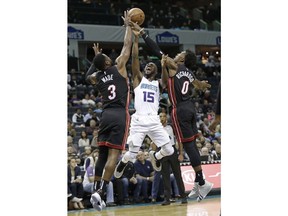 Charlotte Hornets' Kemba Walker (15) tries to shoot between Miami Heat's Dwyane Wade (3) and Josh Richardson (0) in the first half of an NBA basketball game in Charlotte, N.C., Tuesday, Oct. 30, 2018.