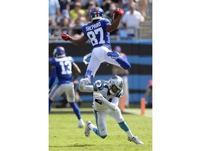 New York Giants' Sterling Shepard (87) is upended by Carolina Panthers' James Bradberry (24) in the first half of an NFL football game in Charlotte, N.C., Sunday, Oct. 7, 2018.