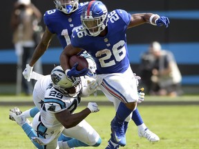 New York Giants' Saquon Barkley (26) runs past Carolina Panthers' Mike Adams (29) in the second half of an NFL football game in Charlotte, N.C., Sunday, Oct. 7, 2018.