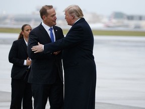 President Donald Trump shakes hands with Rep. Ted Budd, R-N.C., after arriving at Charlotte Douglas International Airport for a campaign rally, Friday, Oct. 26, 2018, in Charlotte, N.C.