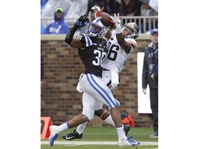 Duke safety Brandon Feamster (30) and Virginia wide receiver Ugo Obasi (86) reach for a pass during the first half of an NCAA college football game in Durham, N.C., Saturday, Oct. 20, 2018. The pass fell incomplete.