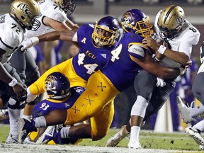 Central Florida's Darriel Mack Jr. (8) is tackled by East Carolina's Alex Turner (94) with Kendall Futrell (44) looking on during the first half of an NCAA college football game in Greenville, N.C., Saturday, Oct. 20, 2018.