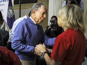 Former New York Mayor Michael Bloomberg talks to a woman who lost her daughter to gun violence after speaking at a rally at City Hall in Nashua, N.H. Saturday, Oct. 13, 2018.