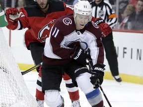 Colorado Avalanche left wing Matt Calvert (11) skates with the puck as New Jersey Devils center Jean-Sebastien Dea (10) chases him during the first period of an NHL hockey game, Thursday, Oct. 18, 2018, in Newark, N.J.