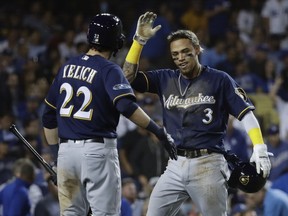 Milwaukee Brewers' Orlando Arcia reacts after scoring from first on a double by Domingo Santana during the fifth inning of Game 4 of the National League Championship Series baseball game against the Los Angeles Dodgers Tuesday, Oct. 16, 2018, in Los Angeles.