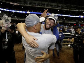 Los Angeles Dodgers' Clayton Kershaw celebrates with manager Dave Roberts after winning Game 7 of the National League Championship Series baseball game against the Milwaukee Brewers Saturday, Oct. 20, 2018, in Milwaukee. The Dodgers won 5-1.
