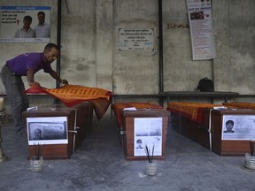 A man offers sacred scarves on coffins containing bodies of South Korean climbers killed over the weekend in a fierce storm on Nepal's Gurja Himal mountain after theywere brought to the Tribhuvan University Teaching Hospital in Kathmandu, Nepal, Tuesday, Oct. 16, 2018. The bodies were driven to the airport and were set to be flown to Seoul, South Korea's capital, later Tuesday. The bodies of five South Korean climbers are heading home amid calls to improve weather warning systems on Nepal's mountains.