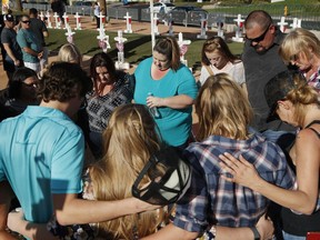 People pray at a makeshift memorial for victims of the Oct. 1 2017, mass shooting in Las Vegas, Sunday, Sept. 30, 2018, in Las Vegas.