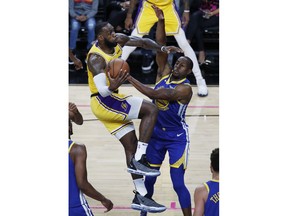 Los Angeles Lakers forward LeBron James, left, is fouled by Golden State Warriors guard Andre Iguodala during the first half of an NBA preseason basketball game Wednesday, Oct. 10, 2018, in Las Vegas.