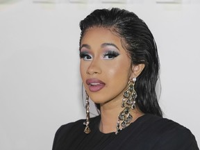 FILE - In this Wednesday, Sept. 5, 2018 file photo, Cardi B attends the Tom Ford SS19 Show at the Park Avenue Armory during New York Fashion Week in New York.  Hundreds of people have lined up in New York City as the rapper handed out free winter coats. The Bronx-born rapper met with residents and fans on Thursday, Oct. 18, 2018 at the Marlboro Houses in Brooklyn during brisk fall weather. The 26-year-old also was given balloons and a cake to celebrate her recent birthday.