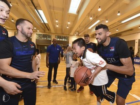 In a photo provided by NBAE, Dallas Mavericks center Salah Mejri, of Tunisia, lifts a participant during the NBA Cares Special Olympics Basketball Clinic, Thursday, Oct. 4, 2018, at Oriental Sports Center in Shanghai. At left is Mavericks guard J.J. Barea.