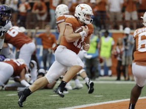 FILE - In this Sept. 22, 2018, file photo, Texas quarterback Sam Ehlinger (11) runs for a 2-yard touchdown against TCU during the second half of an NCAA college football game in Austin, Texas. Ehlinger has thrown for at least 200 yards and a touchdown in the first five games, becoming just the fourth Texas quarterback to do that--and the first in a decade. Texas plays Oklahoma this week.