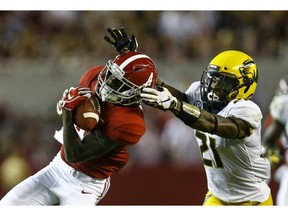 FILE - In this Oct. 13, 2018, file photo, Alabama wide receiver Jerry Jeudy (4) catches a pass over Missouri defensive back Christian Holmes (21) during the second half of an NCAA college football game, in Tuscaloosa, Ala. The sophomore receiver that made the preseason All-America team will be going up against fellow preseason All-America team member Greedy Williams, cornerback at LSU. No. 1 Alabama and No. 4 LSU play on Saturday, Nov. 3 in Baton Rouge, La.