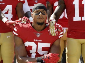 FILE - In this Sept. 10, 2017, file photo, then-San Francisco 49ers safety Eric Reid (35) kneels in front of teammates during the playing of the national anthem before an NFL football game against the Carolina Panthers, in Santa Clara, Calif. Eric Reid says he isn't dropping his grievance against the NFL even after signing a one-year contract with the Panthers, and hasn't made up his mind on how he'll protest racial injustices in the future. In his first comments since rejoining the NFL on Thursday, Reid says he's "still considering other ways of protesting" than kneeling during the national anthem, but wouldn't elaborate.