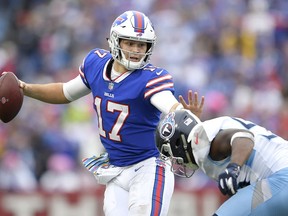 FILE - In this Oct. 7, 2018, file photo, Buffalo Bills quarterback Josh Allen, left, tries to avoid a tackle from Tennessee Titans linebacker Sharif Finch during the second half of an NFL football game, in Orchard Park, N.Y. The Bills have struggled on offense so far and their 221.2 yards a game rank 31st in the league. They're averaging just 121.8 yards passing a game, which is the lowest output in the league.