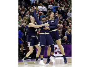 FILE - In this April 1, 2018, file photo, Notre Dame's Arike Ogunbowale, center, celebrates with teammates Marina Mabrey, left, and Kathryn Westbeld after defeating Mississippi State in the final of the women's NCAA Final Four college basketball tournament, in Columbus, Ohio. Both Notre Dame and Louisville enter the season as defending women's basketball champions.