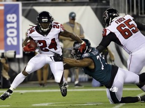 FILe - In this Sept. 6, 2018, file photo, Atlanta Falcons' Devonta Freeman (24) tries to evade Philadelphia Eagles' Michael Bennett (77) during the first half of an NFL football game, in Philadelphia. Freeman, who has missed three straight games with a sore right knee, is expected back this week, just in time to give the Atlanta Falcons a much-needed boost as they prepare to play at Pittsburgh.