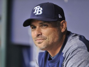 FILE - In this Aug. 23, 2018, file photo, Tampa Bay Rays manager Kevin Cash sits in the dugout before a baseball game against the Kansas City Royals, in St. Petersburg, Fla. The Tampa Bay Rays, who won more games than any American League team that didn't make the playoffs, have rewarded manager Kevin Cash with a contract extension that runs through 2024, plus a club option for 2025.