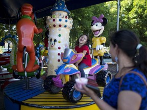 Five-year-old Alexa laughs with her mother, Araceli Ramos, while riding a merry-go-round at a park in San Miguel, El Salvador, on Aug. 18, 2018. Ramos scraped together $6,000 to pay a smuggler who could help her escape from the man who she said warned her she'd "never be at peace." On the month-long, 1,500-mile pilgrimage, she carried Alexa, a change of clothes, diapers, cookies, juice and water.