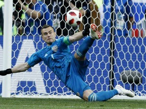 FILE - In this July 1, 2018, file photo Russia goalkeeper Igor Akinfeev catches a penalty shot during the round of 16 match between Spain and Russia at the 2018 soccer World Cup at the Luzhniki Stadium in Moscow, Russia. Akinfeev, whose penalty shootout saves helped the World Cup host nation eliminate Spain, has retired from the national team.