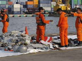 FILE- In this Monday, Oct. 29, 2018, file photo members of Indonesian Search and Rescue Agency (BASARNAS) inspect debris recovered from near the waters where a Lion Air passenger jet is suspected to crash, at Tanjung Priok Port in Jakarta, Indonesia. A Lion Air flight crashed into the sea just minutes after taking off from Indonesia's capital on Monday. The deadly crash has renewed questions about the safety of Indonesian airlines soon after U.S. and European regulators removed prohibitions against them.
