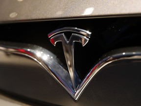 FILE- This Oct. 3, 2018, file photo shows a Tesla emblem at the Auto show in Paris. Shares of Tesla Inc. soared Tuesday, Oct. 23, a day ahead of the company's third-quarter earnings release.