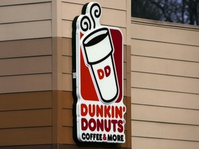 FILE- This Jan. 22, 2018, file photo shows the Dunkin' Donuts logo on a shop in Mount Lebanon, Pa. First, Dunkin' dropped the "Donuts" from its name. Now, it's adding espresso drinks to its menu. Dunkin' says most of its 9,200 U.S. stores will offer lattes, cappuccinos and other espresso-based hot and cold drinks by the holiday season.