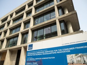 FILE- In this Aug. 27, 2018, file photo a sign stands at the construction site for the Consumer Financial Protection Bureau's new headquarters in Washington. The nation's financial watchdog has opened a formal investigation into writings and comments by Eric Blankenstein, a Republican appointee overseeing the agency's anti-discrimination efforts, which he alleged that most hate crimes were fake and argued that using racial epithets did not mean a person was racist.