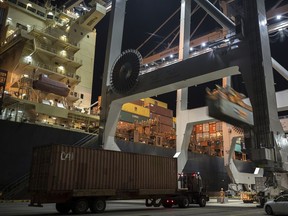 In this July, 5, 2018 photo, a post-Panamax crane loads a 40-foot shipping container onto a container ship at the Port of Savannah in Savannah, Ga. On Friday, Oct. 5, the Commerce Department reports on the U.S. trade gap for August.