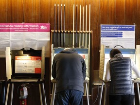 FILE - In this Nov. 8, 2016, file photo, residents of Chicago' 33rd Ward mark their ballots at Marie's Golden Cue pool hall. A security lapse last year by voting system vendor Election Systems & Software publicly exposed data on Chicago's 1.8 million voters for months online. The lapse provided a rare moment of public accountability for a closely held business that is a front-line guardians of U.S. election security.