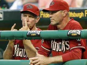 FILE - In this June 8, 2011 file photo, Arizona Diamondbacks bench coach Alan Trammell, left, gives signals standing next to manager Kirk Gibson during the fifth inning of a baseball game against the Pittsburgh Pirates in Pittsburgh. Stealing signs is as much a part of baseball tradition as stealing bases, but the technology available now could open a whole new frontier of competitive sleuthing.