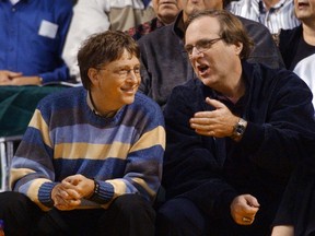 FILE - In this March 11, 2003 file photo, Microsoft Chairman Bill Gates, left, chats with Portland Trail Blazers owner and former business partner Paul Allen during a game between the Trail Blazers and Seattle SuperSonics in Seattle.  Allen, billionaire owner of the Trail Blazers and the Seattle Seahawks and Microsoft co-founder, died Monday, Oct. 15, 2018 at age 65. Earlier this month Allen said the cancer he was treated for in 2009, non-Hodgkin's lymphoma, had returned.