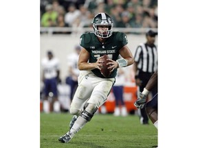 FILE - In this Aug. 31, 2018, file photo, Michigan State quarterback Brian Lewerke scrambles against Utah State during the fourth quarter of an NCAA college football game in East Lansing, Mich. It's been an up-and-down season for Lewerke, who now faces the nation's top-ranked pass defense when the Spartans take on Michigan this weekend.