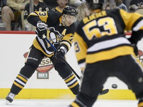 FILE - In this Sept. 23, 2018, file photo, Pittsburgh Penguins' Jack Johnson (73) passes to Teddy Blueger (53) during an NHL preseason hockey game against the Detroit Red Wings in Pittsburgh. The Penguins signed Johnson to a five-year deal in July and he's ready to show them he's worth the long-term investment. The veteran defenseman will make his debut with the Penguins on Thursday against the Washington Capitals.