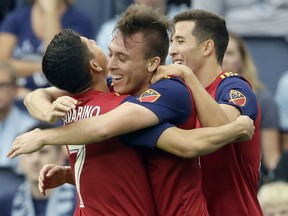 FILE - In this Sunday, Sept. 30, 2018, file photo, Real Salt Lake forward Corey Baird (27) celebrates his goal with teammates Jefferson Savarino (7) and Aaron Herrera (22) during the first half of an MLS soccer match against Sporting Kansas City in Kansas City, Kan. Real Salt Lake earned a much needed point to stay alive in the playoff hunt when they drew 1-1 on the road in Kansas City.