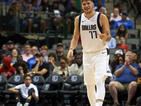FILE - In this Saturday, Sept. 29, 2018, file photo, Dallas Mavericks guard Luka Doncic (77) celebrates after hitting a 3-pointer against the Beijing Ducks during the second half of an NBA exhibition basketball game in Dallas. Doncic has help from plenty of angles as a teenager transitioning from European ball to the NBA with the Mavericks.